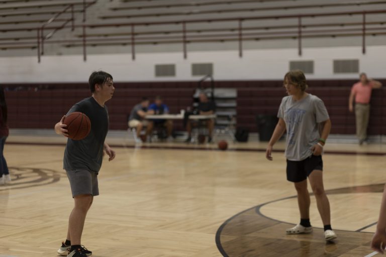 Students playing one on one basketball.