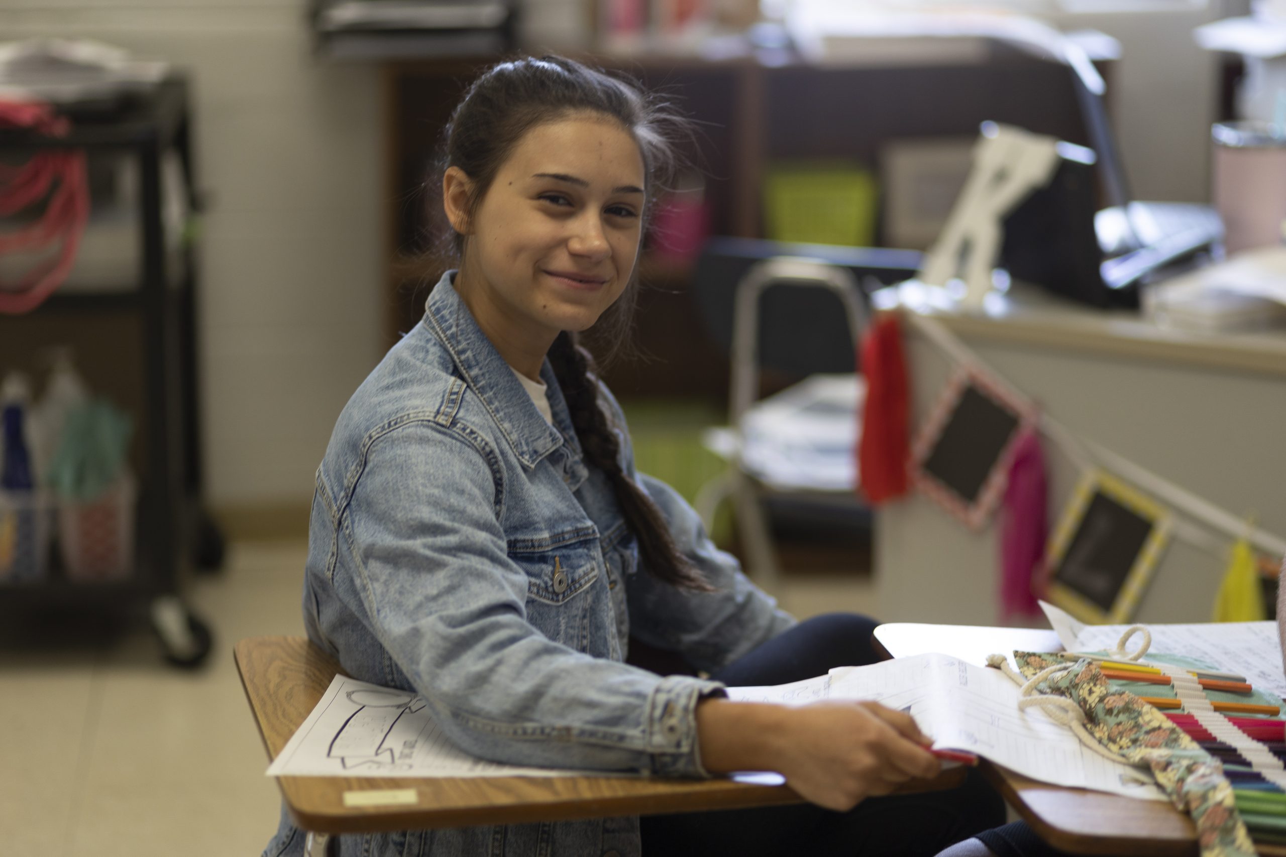 A smiling female student seated at desk.