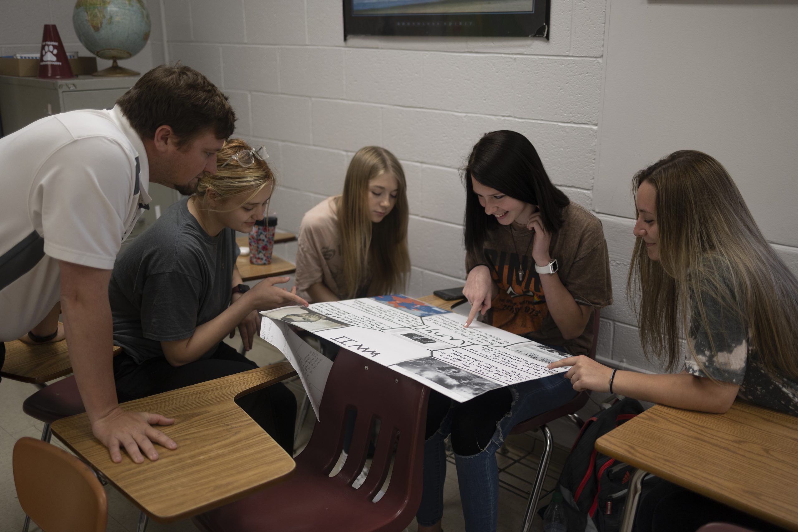 A group of students viewing a poster board project.