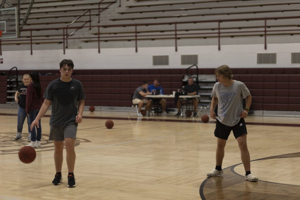 Two male students playing basketball.